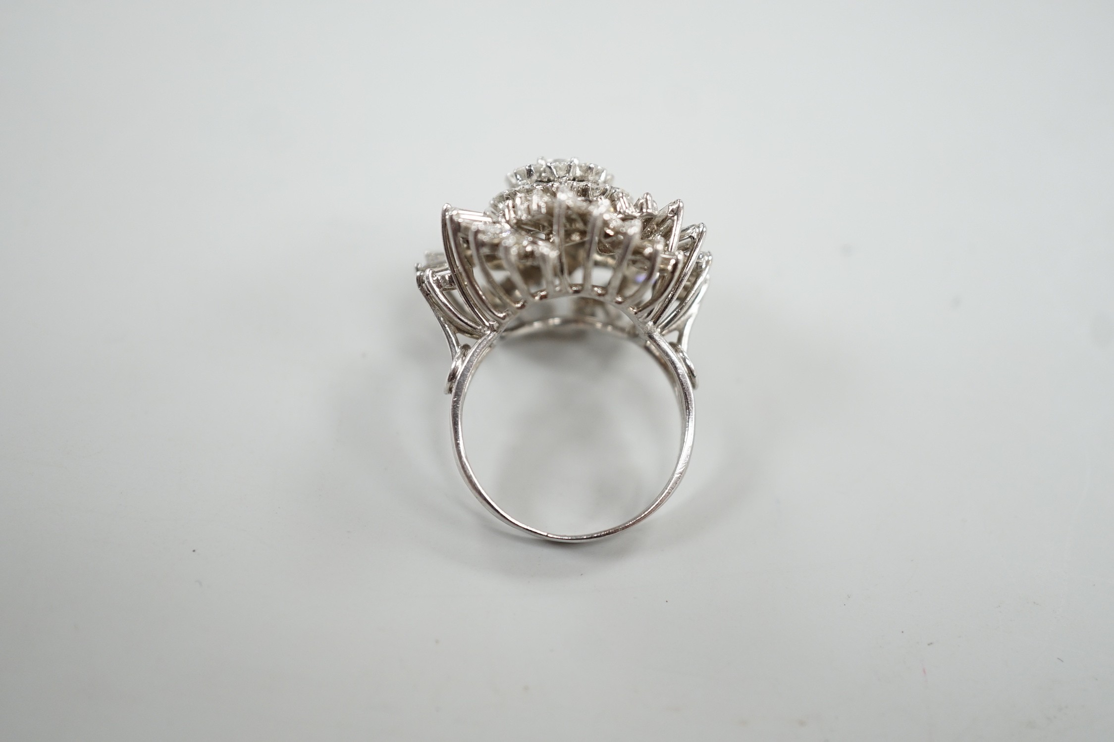 A white metal, baguette and round cut diamond spiral cluster set dress ring, size P, gross weight 14.7 grams.